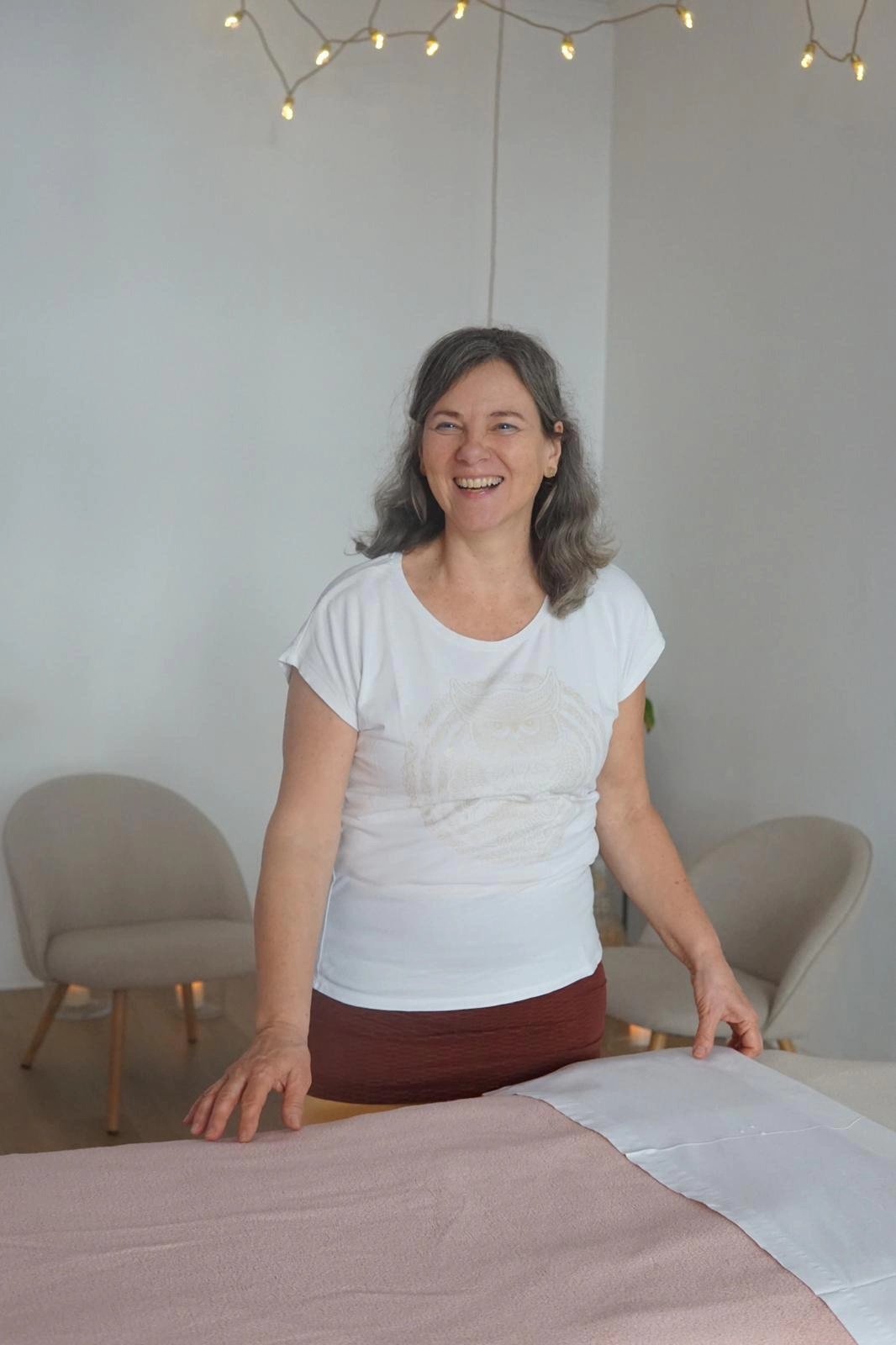 Susanne lachend an der Massageliege
